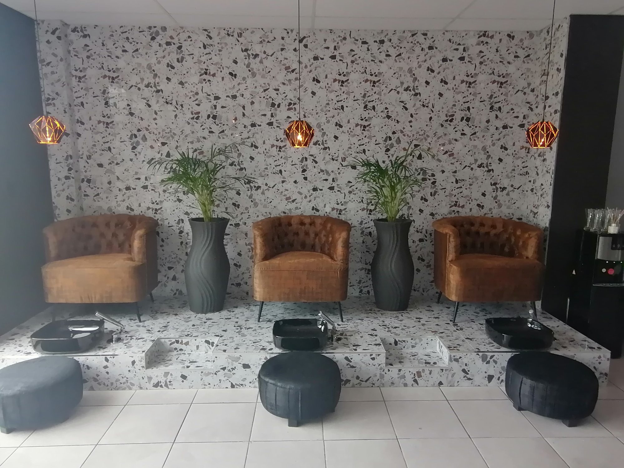 Revive pedicure lounge with tufted chairs and terrazzo platform