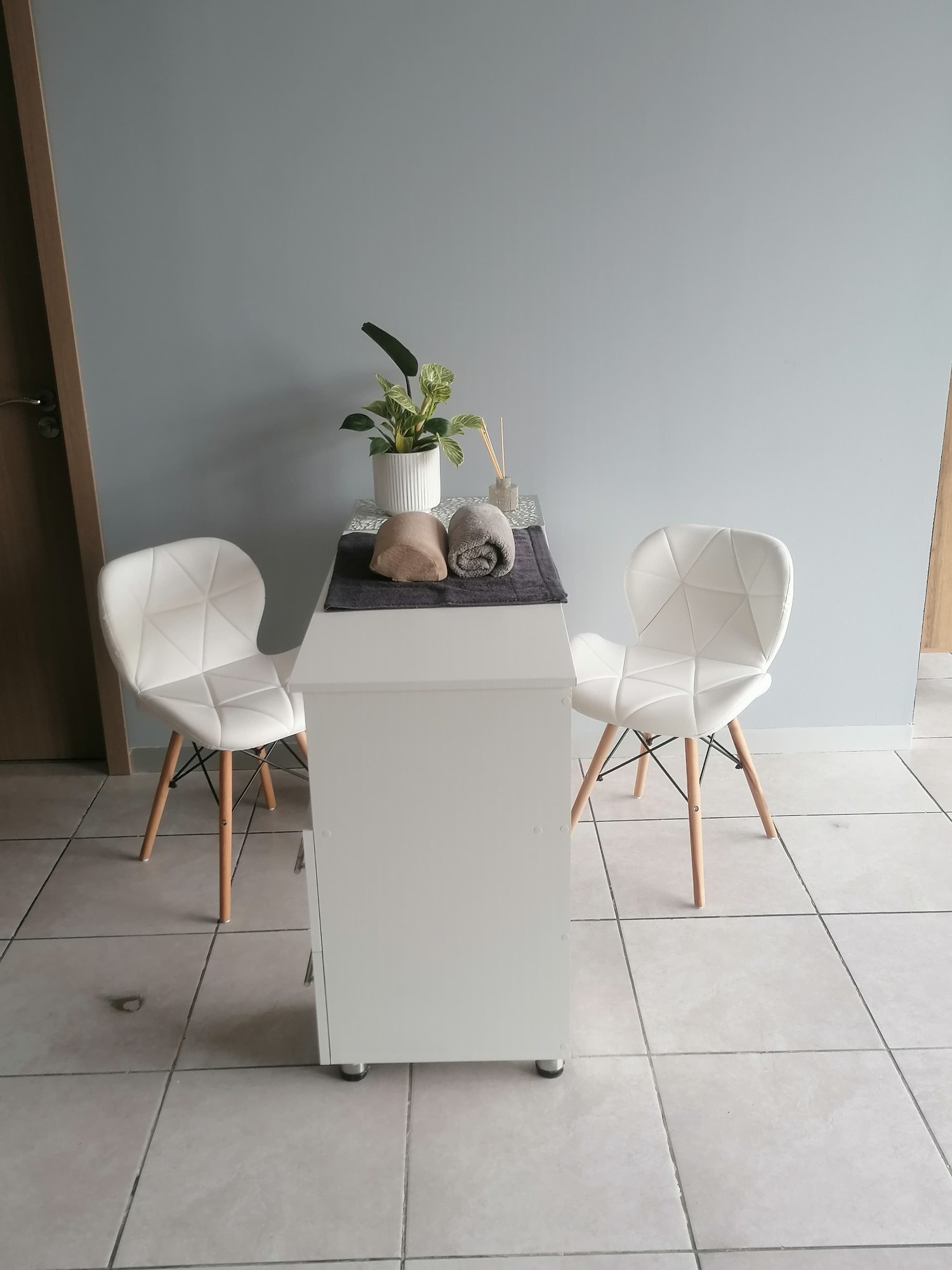 Manicure station with white chairs and plant detail